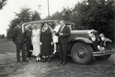 811869 Afbeelding van enkele leden van het gezin van W.H.J. Bruschwiler bij hun auto, in een landelijke omgeving, ...